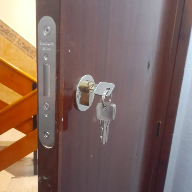 Cerradura Baton nueva con bombín y juego de llaves en puerta de vivienda
